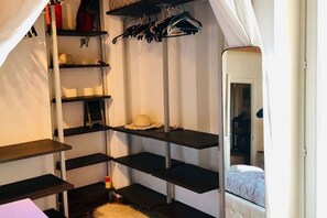 A bedroom with a bed, a wardrobe, and shelves.