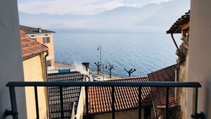 A view from a balcony overlooking a body of water with mountains in the background. - Cà Milla Argegno apartment (Argegno)
