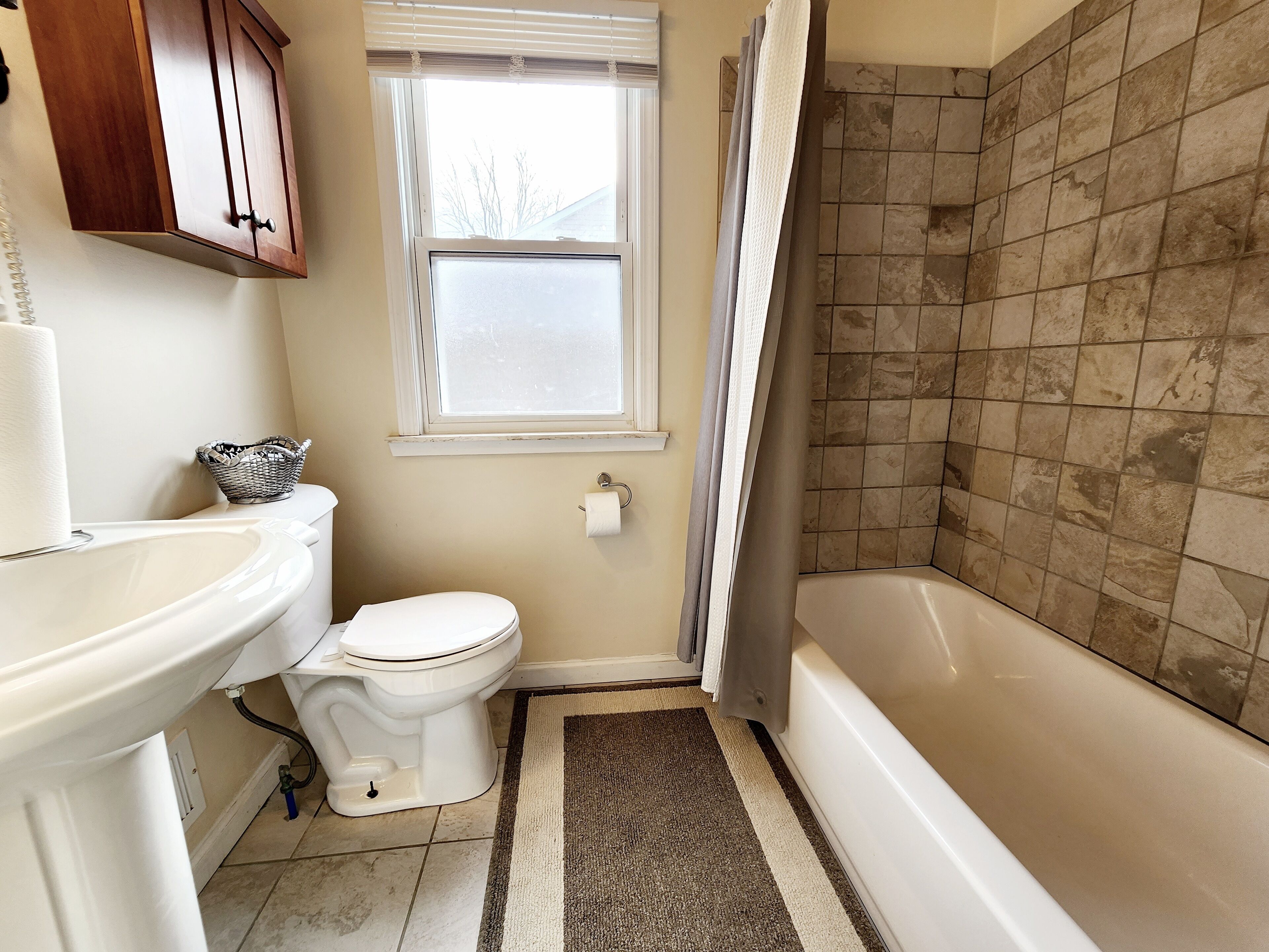 Ein Badezimmer mit Toilette, Waschbecken, Badewanne und Dusche.