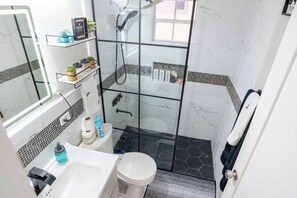 Een bad/douchecombinatie, een haardroger, handdoeken, zeep