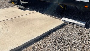 Un camping-car noir et blanc avec le mot « TORQUE » écrit sur le côté, équipé d’une petite rampe d’accès et d’une porte coulissante.