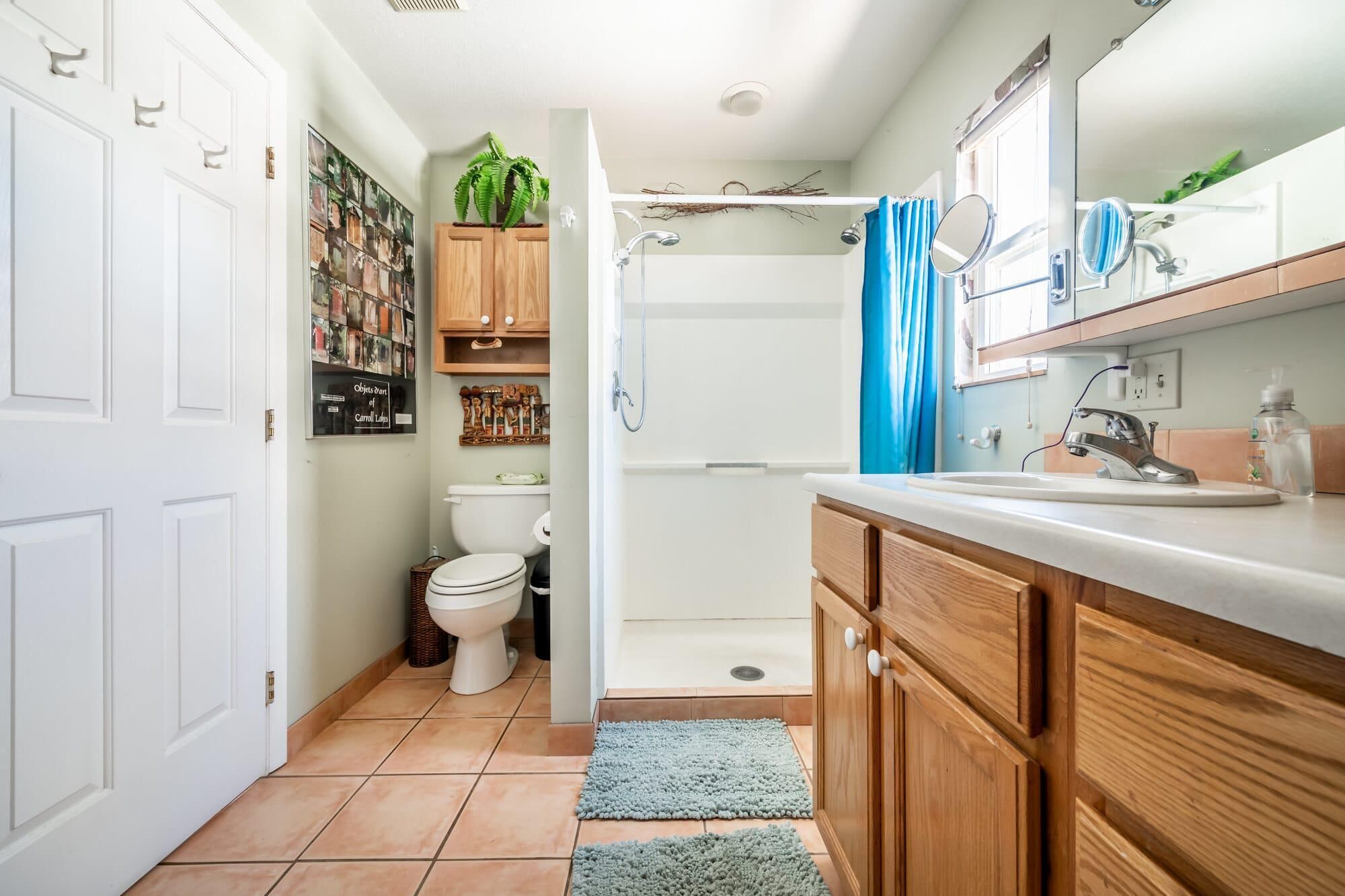 A compact bathroom with a toilet, shower, and sink.