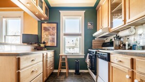 Une cuisine compacte avec des meubles en bois, un lave-vaisselle et une fenêtre qui laisse entrer la lumière naturelle.