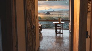 Een gang die uitkomt op een balkon met uitzicht over het landschap.