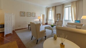 A spacious living room with a white sofa, a round coffee table, and a decorative screen. - Raso cozy penthouse near the Duomo (Firenze)