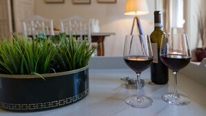 A dining table with two wine glasses and a bottle of wine, a potted plant, and a lamp in the background. - Raso cozy penthouse near the Duomo (Firenze)