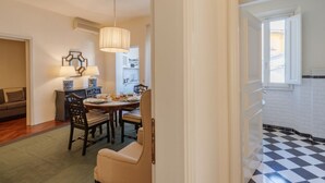 Uma área de refeições com mesa, cadeiras e um lustre.