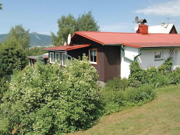A house with a red roof, white walls, and a small window.