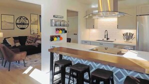 A modern kitchen with a central island, bar stools, and a coffee bar. - Modern getaway! Relax, bike, hike, and shred! (Angel Fire)