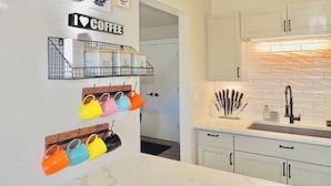 A modern kitchen with white cabinets, a marble countertop, and a built-in oven. - Modern getaway! Relax, bike, hike, and shred! (Angel Fire)