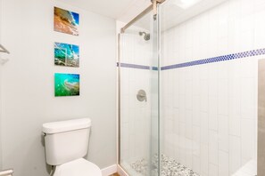 Een douche, handdoeken, zeep, toiletpapier