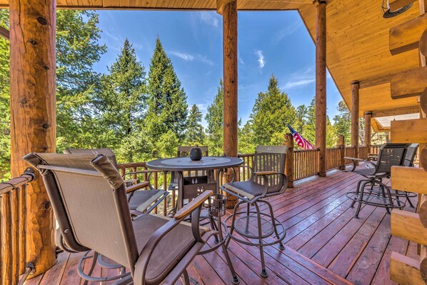A wooden deck with outdoor furniture, a table, and chairs. - Quiet Ruidoso Cabin w/ Deck & Private Hot Tub (Ruidoso)