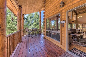 A wooden cabin with a porch, large windows, and a dining area. - Quiet Ruidoso Cabin w/ Deck & Private Hot Tub (Ruidoso)