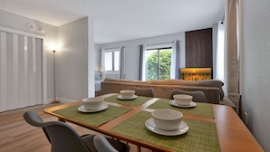 A dining area with a wooden table set for four, green placemats, and white bowls. - Excellent Resort Studio near Universal & Disney (Orlando)