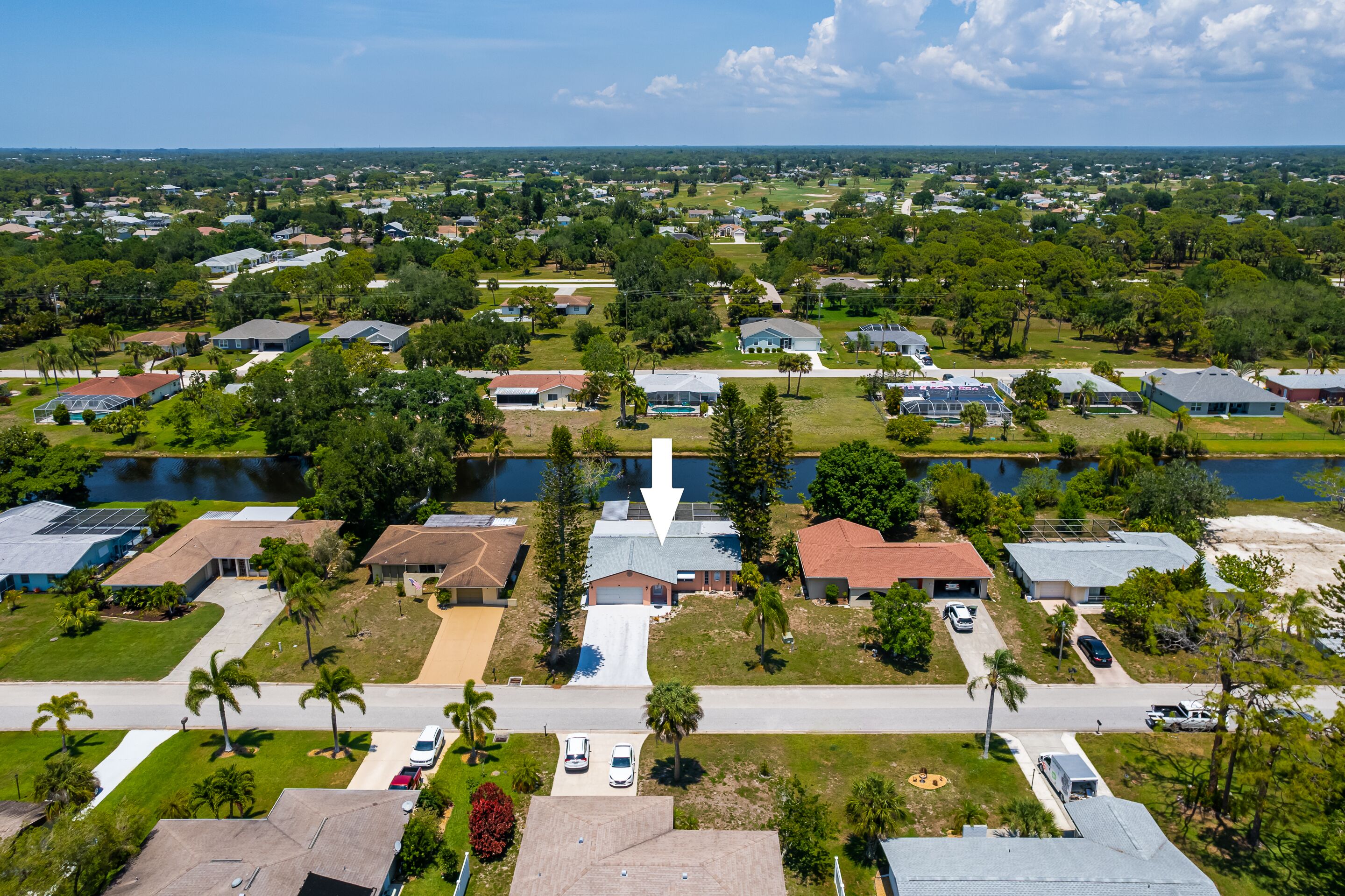 A residential area with houses, a road, and a body of water.