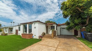 Une maison de plain-pied avec un porche à l’avant, un garage et une pelouse bien entretenue.
