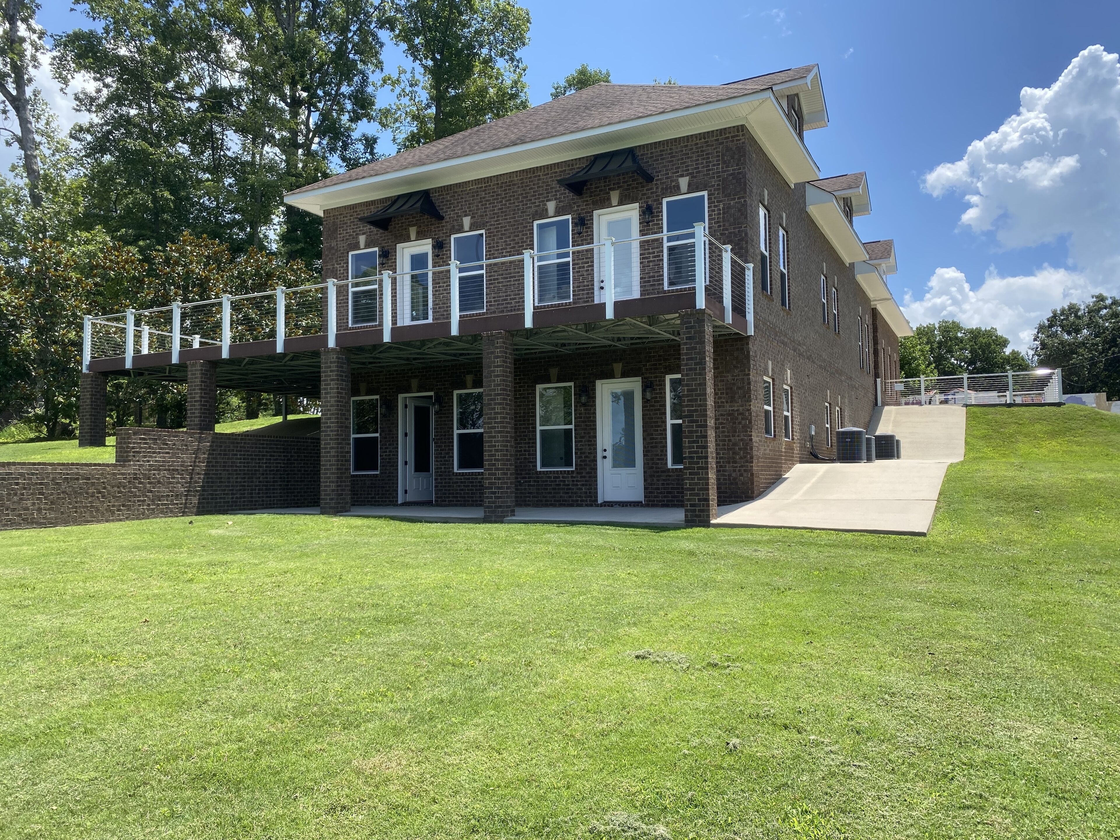 A two-story brick building with a covered porch and a ramp leading to the entrance.