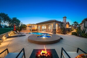 A residential property with a swimming pool, outdoor seating, and a fire pit.