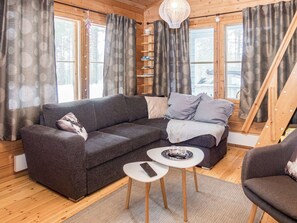 A cozy living room with a grey sofa, a coffee table, and a bookshelf. - Piilola nr 1 by Interhome (Kuusamo)
