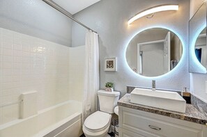 Banheira, secador de cabelo, toalhas de banho, shampoo