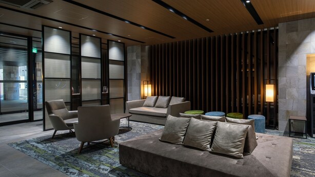 A modern lobby with a sofa, chairs, and a patterned rug. - IROHA GRAND HOTEL KINTETSUNARAEKIMAE (Nara)