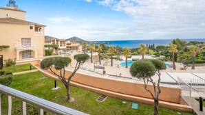 A coastal resort with a pool, palm trees, and a view of the sea. - Le Village (E1 214) by Interhome (Agay Village Cap Esterel)
