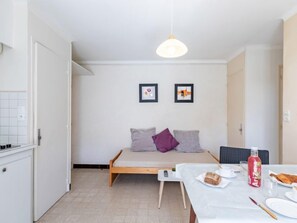 A small, bright room with a bed, a table with breakfast, and two framed pictures on the wall. - Super Plage by Interhome (Saint Cyr sur mer Les Lecques)