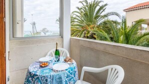 Ein Balkon mit einem Tisch für zwei Personen, einer Champagnerflasche und einer Fruchtschale.