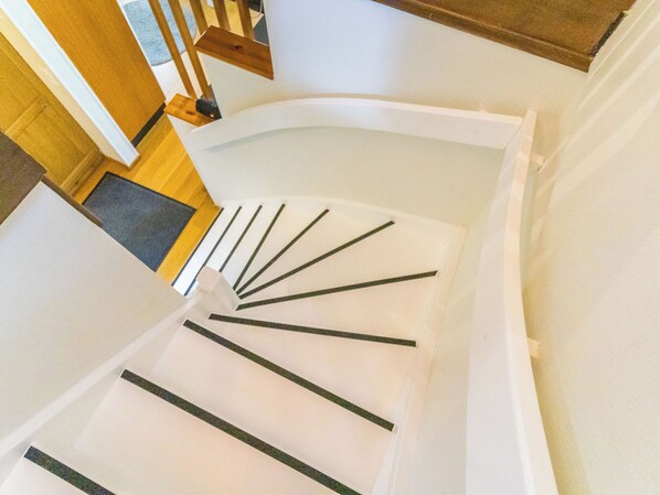 Una escalera de caracol con escalones blancos y barandillas negras.