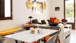 A modern dining area with a table, chairs, and a hanging light fixture. - Edifici Port del Rei by Interhome (L'Escala)
