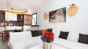 A modern living room with a sofa, a dining area, and a kitchen. - Edifici Port del Rei by Interhome (L'Escala)