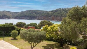 A coastal landscape with a view of the sea, hills, and a building with a red roof. - Edifici Port del Rei by Interhome (L'Escala)