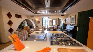 Une cuisine moderne dotée d’un îlot central, d’un four encastré et d’un coin repas avec des chaises et une table.
