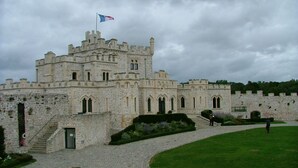 A castle-like building with a flag, stone walls, and a grassy courtyard. - Condette, ideally located house! (Condette)
