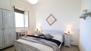 Ein Schlafzimmer mit Bett, Nachttischen, Schreibtisch und Kleiderschrank.