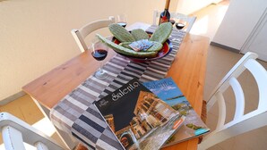Ein Esstisch mit Kakteenarrangements, Weingläsern und einer Zeitschrift mit dem Titel 'Salento'.