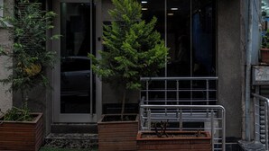 The exterior of Laos Hotel with a prominent sign, large windows, and potted plants. - Laos Otel (Istanbul)