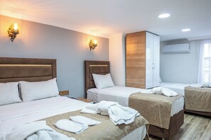A hotel room with two beds, a wooden headboard, a wardrobe, and a wall-mounted air conditioner. - Laos Otel (Istanbul)