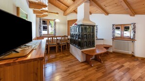A wooden interior with a television, a stove, and a dining area.