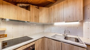 A modern kitchen with wooden cabinets, a stainless steel sink, and a built-in oven.