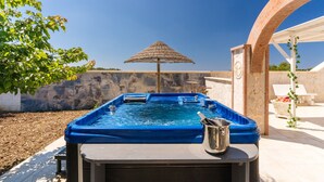 Un bain à remous avec un mur en pierre et une pergola en arrière-plan.