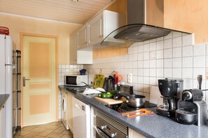 Cozinha equipada com micro-ondas, torradeira, máquina de café e diversos utensílios.