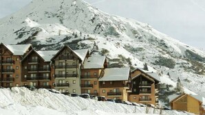 A mountain lodge with multiple buildings, a ski slope, and a snow-covered mountain in the background. - Vacation Apartment "Ski-In/Ski-Out" Perfectly Located Year-Round (Valmeinier)