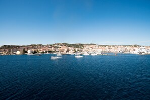 Une ville côtière avec des bâtiments le long du front de mer et des bateaux sur l’eau.