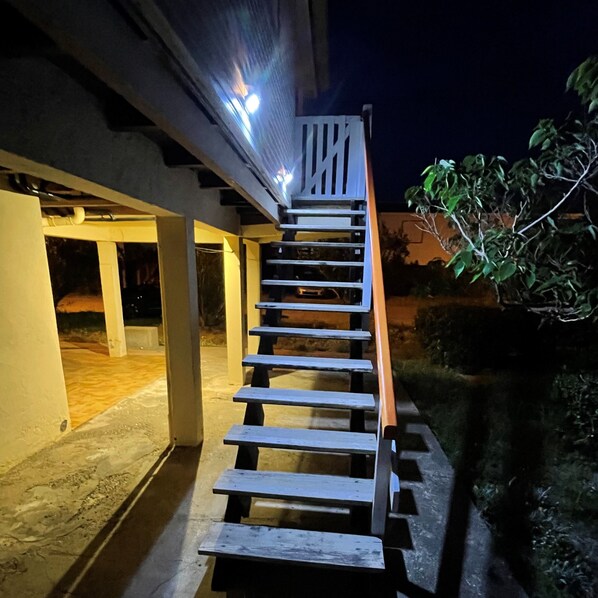 Una escalera de madera que conduce a la entrada de un edificio, de noche.