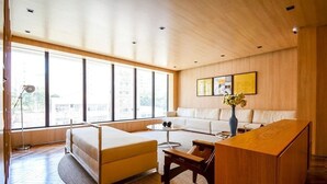Un salon moderne avec un canapé, une table basse et un bureau en bois.