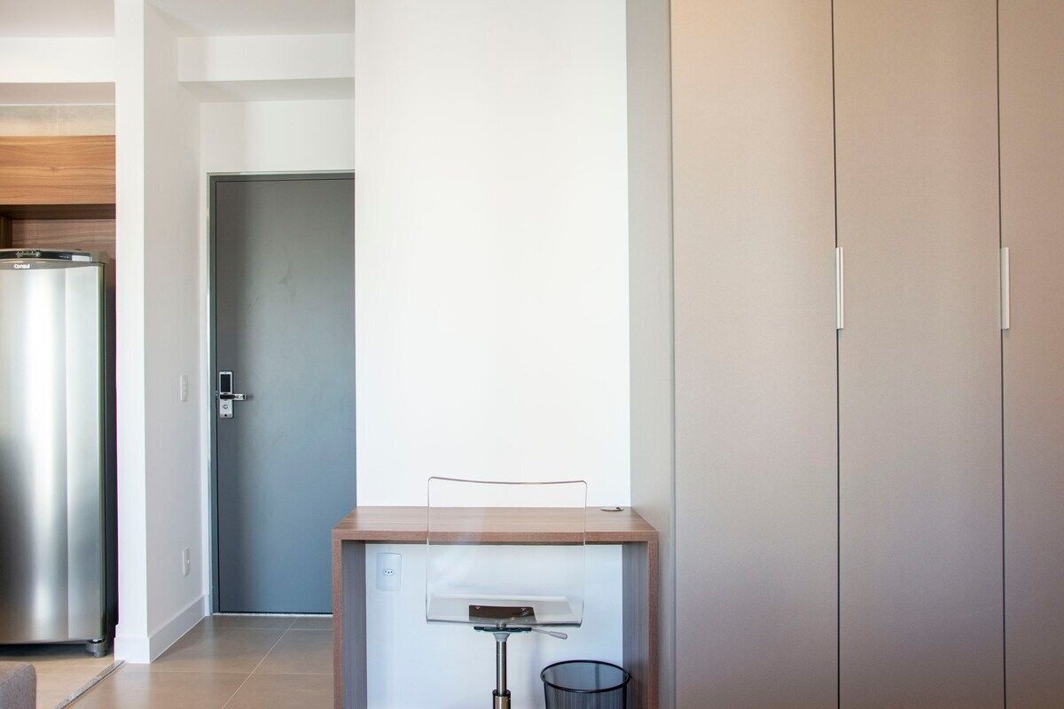 Een moderne keuken met een ingebouwde koelkast, een houten aanrecht en een deur naar een andere kamer.