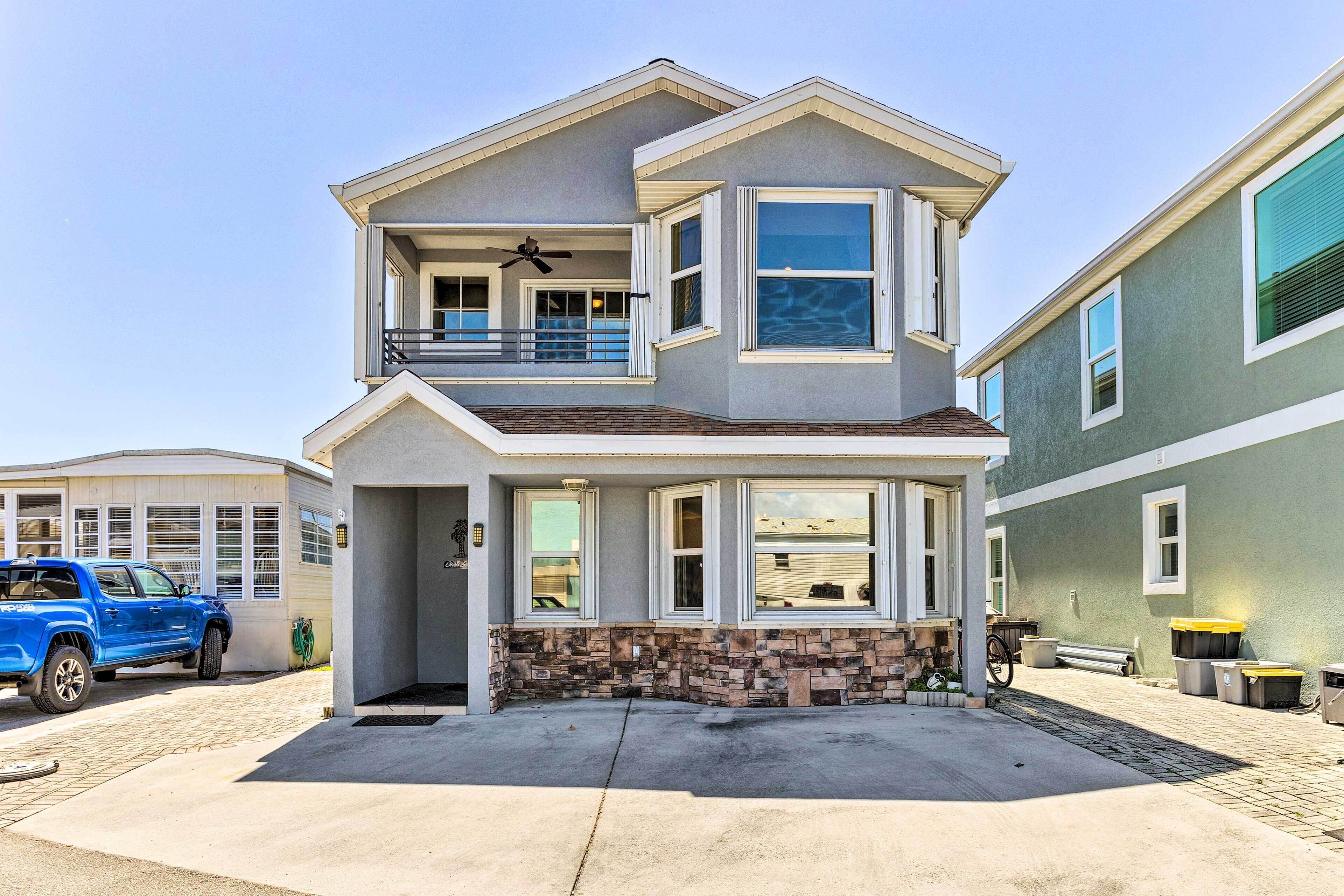 A two-story house with a balcony, a garage, and a driveway.