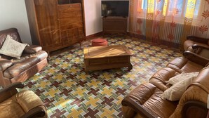 A living room with a brown leather sofa, a wooden coffee table, a wooden cabinet, and a television. - Country house ! 5 minutes from the village center. (Caromb)