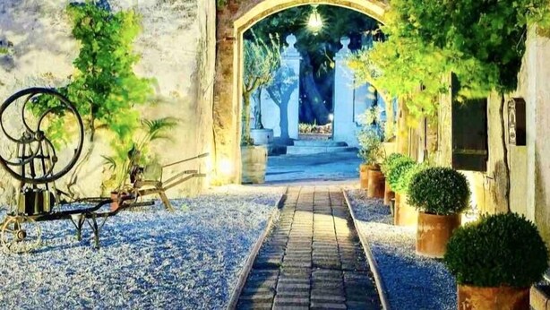A pathway leading to a covered entrance with a bicycle and potted plants on either side. - Face a le Mer Fleury (Fleury)